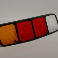 A rear left side red tail light lens for Porsche 928s.