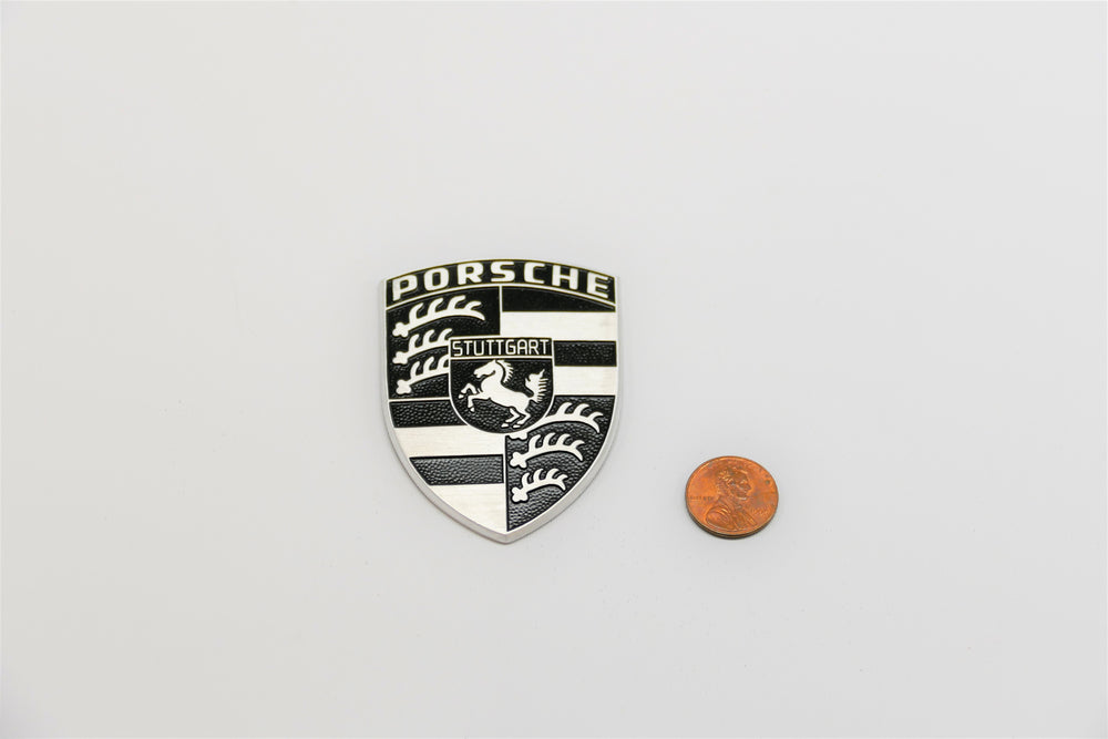 A Porsche emblem badge on top of spider for Porsche 928s.